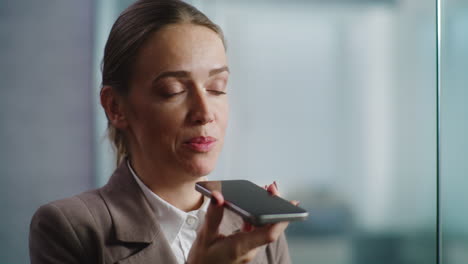 businesswoman using smartphone for voice recording or call