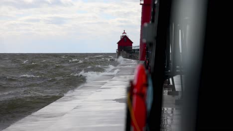 Waves-crashing-on-Grand-Haven,-Michigan-pier-and-lighthouse-on-Lake-Michigan