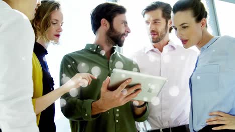 compañeros de trabajo discutiendo sobre una tableta digital rodeados por el efecto de burbujas blancas