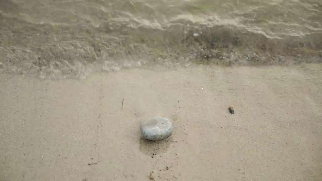 Small sea waves splashing over beach stones