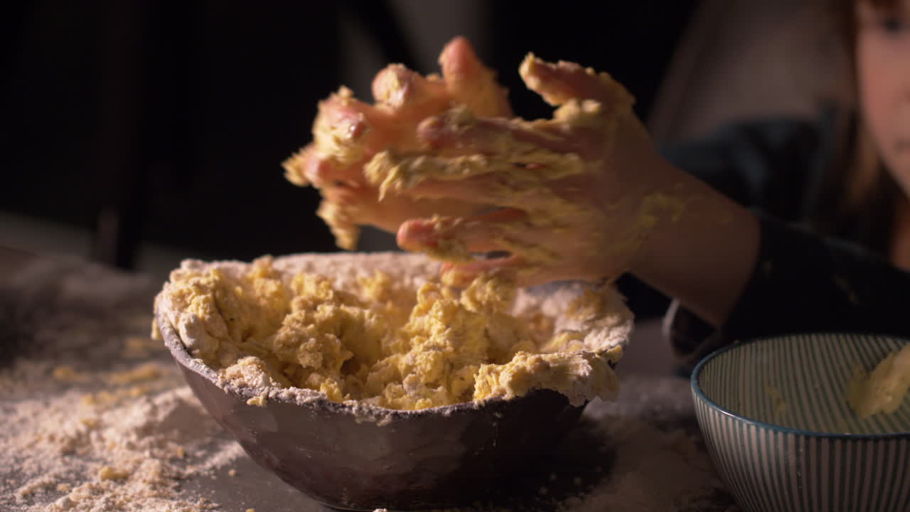Little girl rubbing messy hands full of butter dough mix, preparing for baking