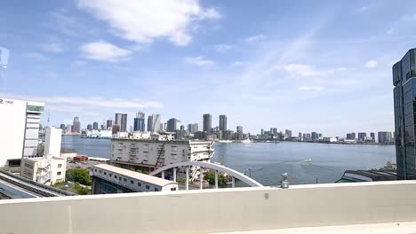 a dynamic view of tokyo's skyline from a moving vehicle, showcasing modern architecture and a clear blue sky
