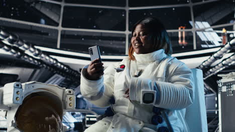 cheerful female astronaut records selfie video with smartphone