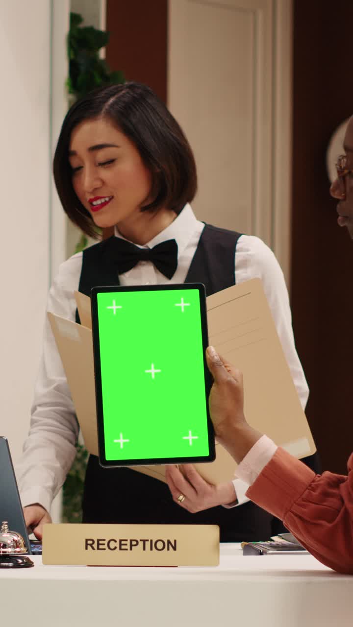 Hotel reception with green screen tablet
