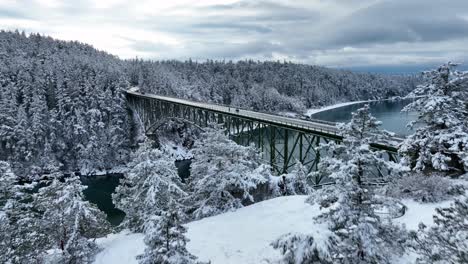 disparo de drones volando hacia arriba y sobre el puente de paso de engaño con nieve cubriendo el suelo