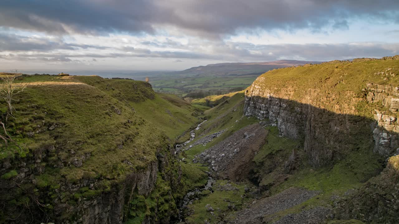 imágenes de lapso de tiempo mientras la luz se desvanece mirando hacia abajo mousegill beck con el valle del edén y los peninos del norte en el fondo, cumbria, reino unido