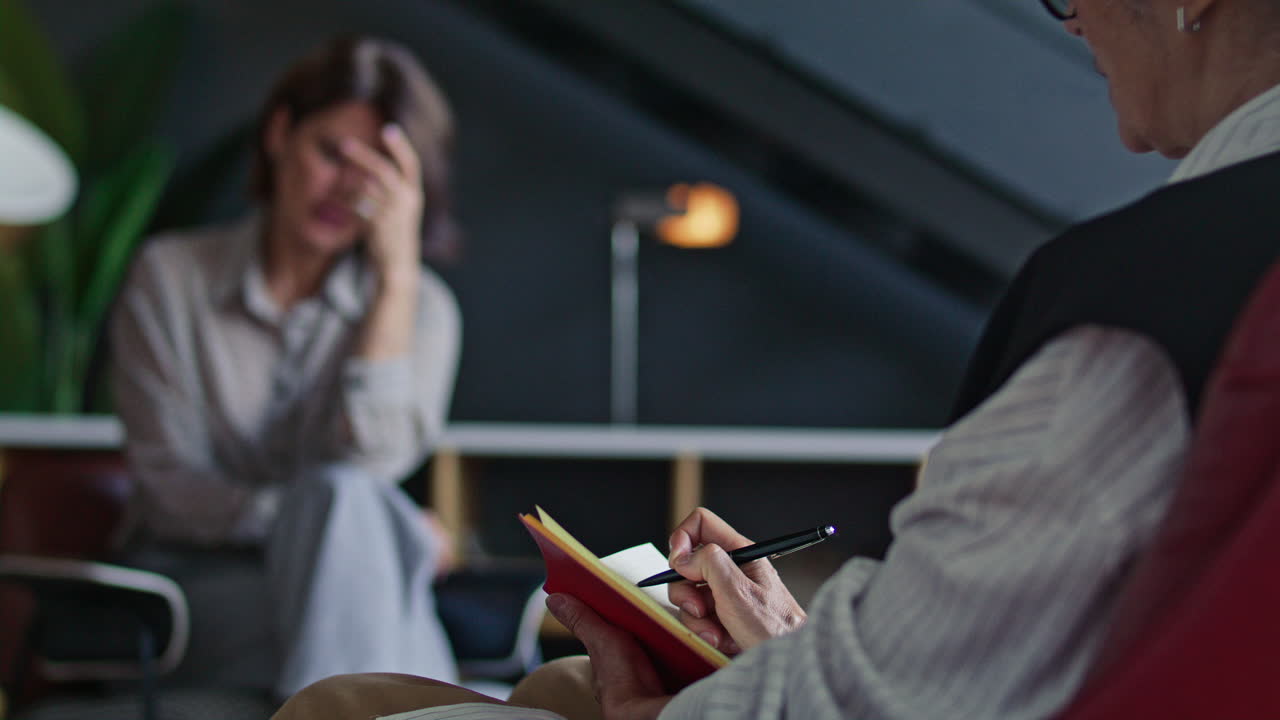Female Therapist Taking Notes during Counseling Session with Patient