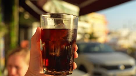 ice cooled cola soda drink in exotic restaurant in tenerife, pov hold view