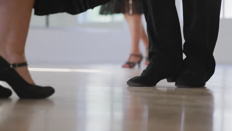 mixed race male dance teacher taking a ballroom dancing class at a dance studio
