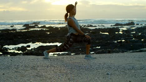 Woman-exercising-on-beach-at-dusk-4k