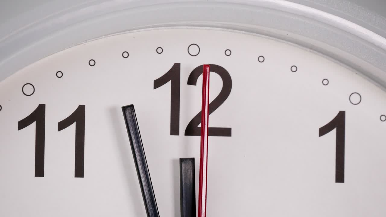 White wall clock tells 3  minutes to arrive at noon.