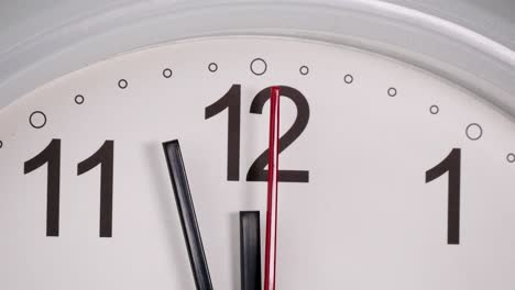 el reloj de pared blanco dice tres minutos para llegar al mediodía.