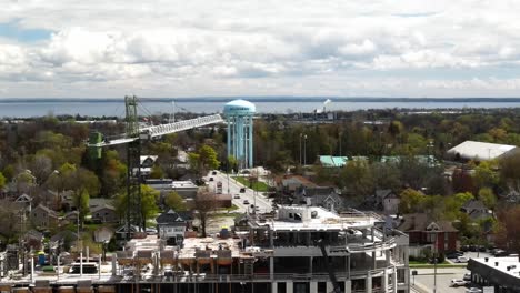 Drone-flying-over-a-Collingwood-construction-looking-out-at-a-crane-with-Georgian-Bay-in-the-distance