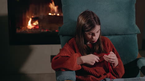 girl knitting by the fireplace