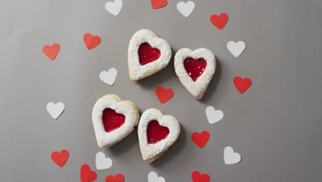 paper hearts and cakes on green background at valentine's day