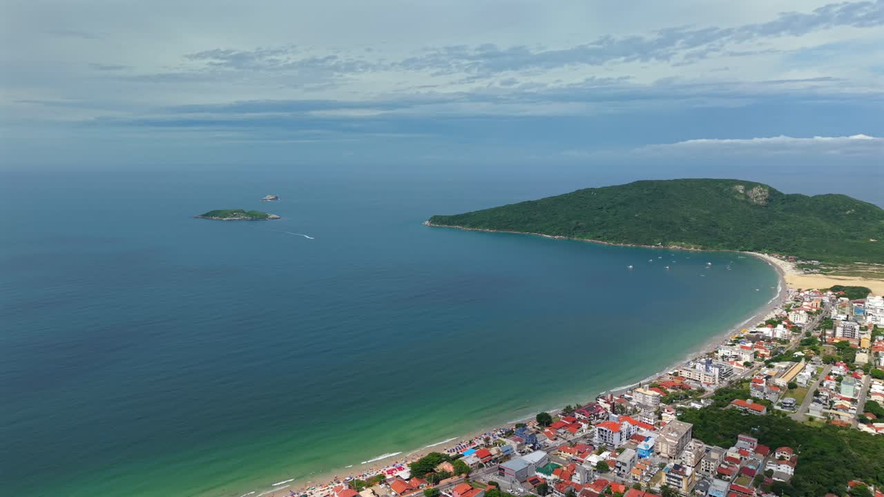 Ilha Mata Fomen rannikon rakennukset ja Inglesesin ranta, Florianópolis, osittain pilvisenä päivänä. Hitaasti etääntyvä ilmakuva.
