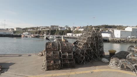 ollas de langosta apiladas en el muelle esperan a los pescadores en un día soleado junto al mar