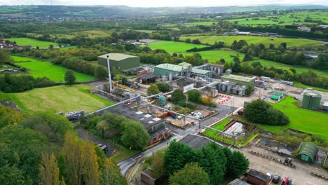 aerial footage approaching a uk chemical plant, showcasing pipelines, metal structures, cooling towers, and chemical storage