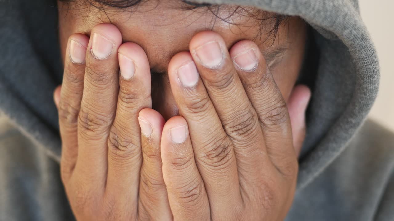 Man Hiding Face in Hands