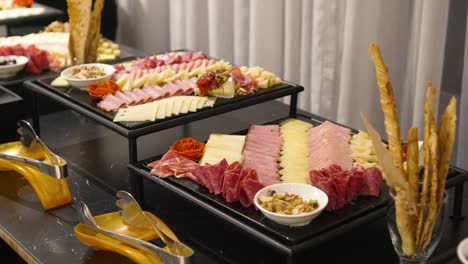 buffet table with cheeses, bacon and hams, during the banquet in the wedding celebration room