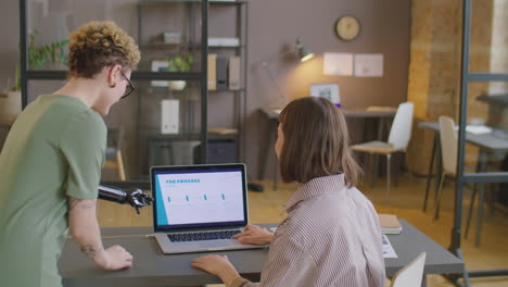 Woman with Prosthetic Arm Discussing Business Presentation with Colleague