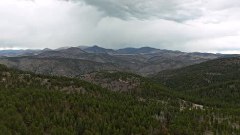 Retroceso-Aéreo-Sobre-Montañas-Rocosas-Cubiertas-De-árboles-De-Hoja-Perenne-Que-Crean-Un-Patrón-De-Paisaje-Boscoso-Natural