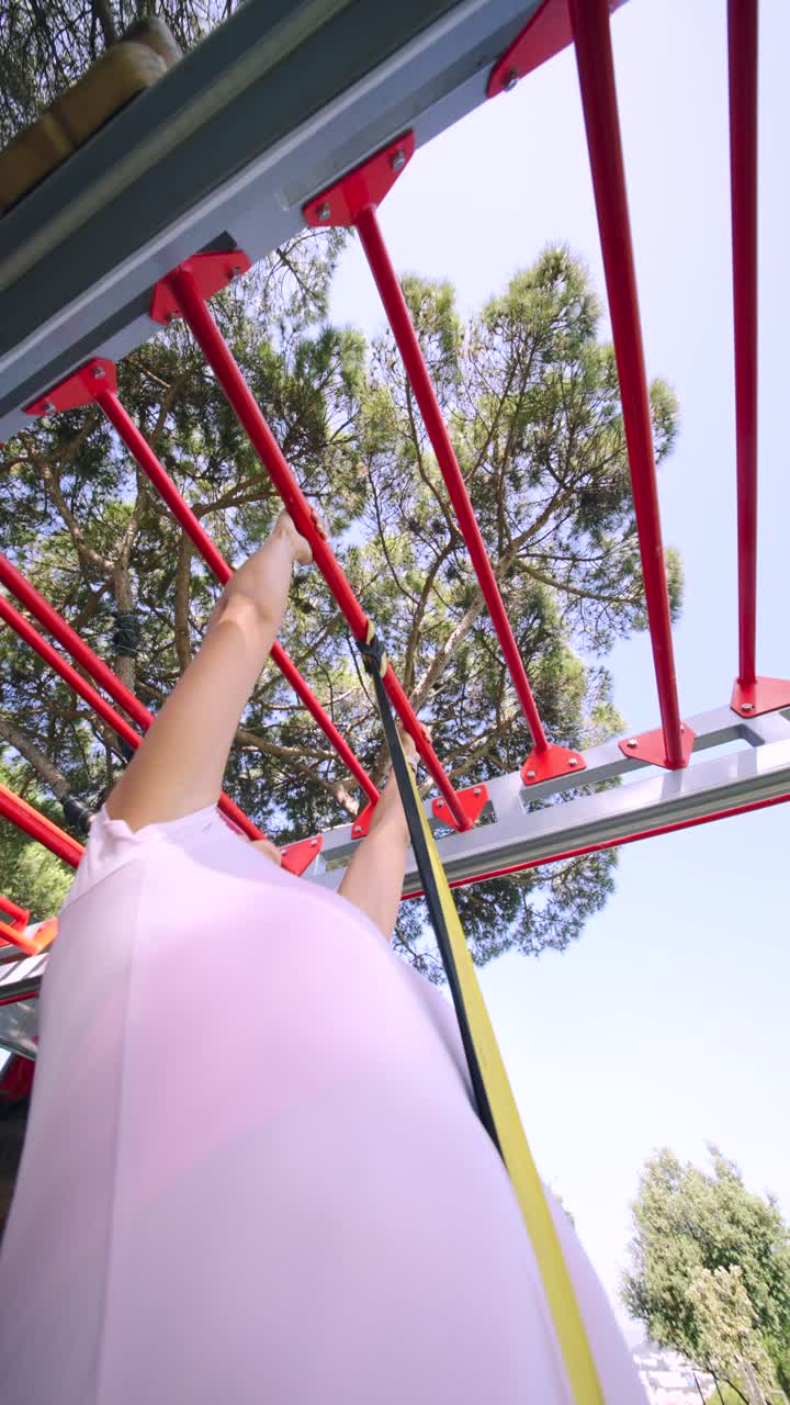 Woman working out on outdoor fitness equipment