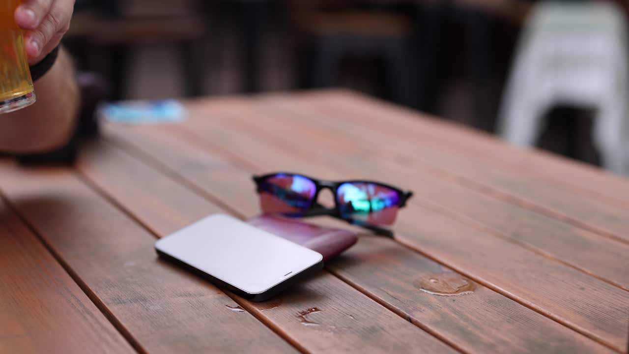 persona recoge cerveza, interactúa con el teléfono inteligente