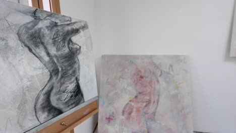 canvases of abstract nudes in home studio