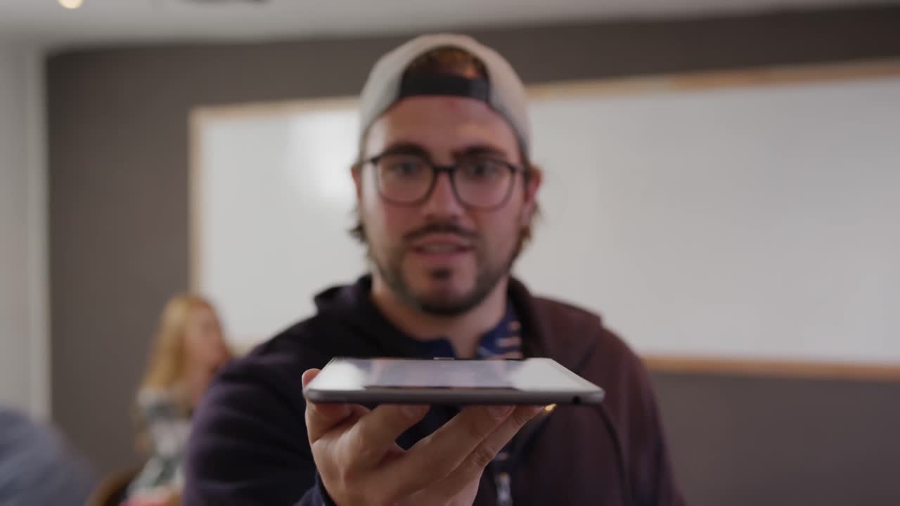 hombre caucásico sosteniendo una tableta de computadora en la oficina creativa