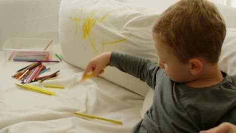 niño con lápiz de color en el sofá 4k