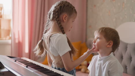 girl catches little boy falling down near piano at home