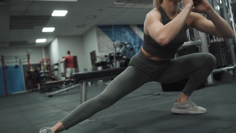 dynamic stretching of young caucasian woman on a gym.