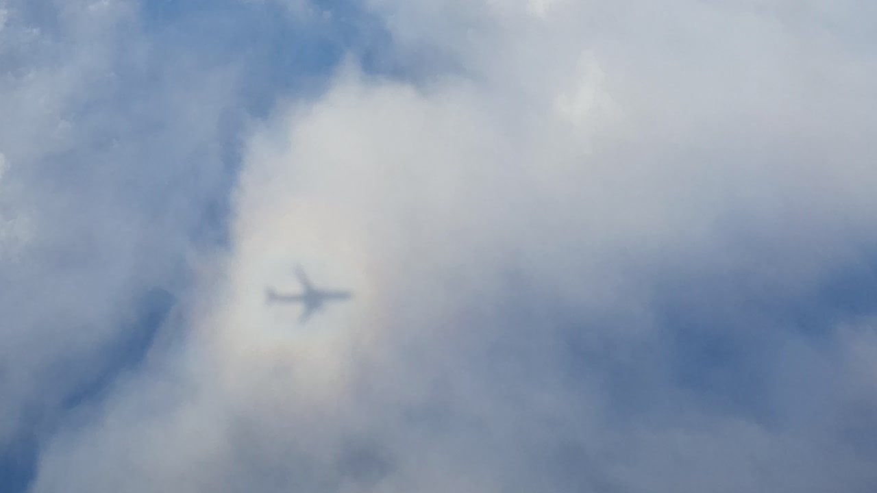 브로큰 스펙터 또는 소위 태양의 영광과 함께 구름에 드리워진 비행기의 그림자