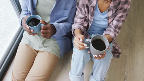 video of midsection of african american couple drinking coffee and talking at home