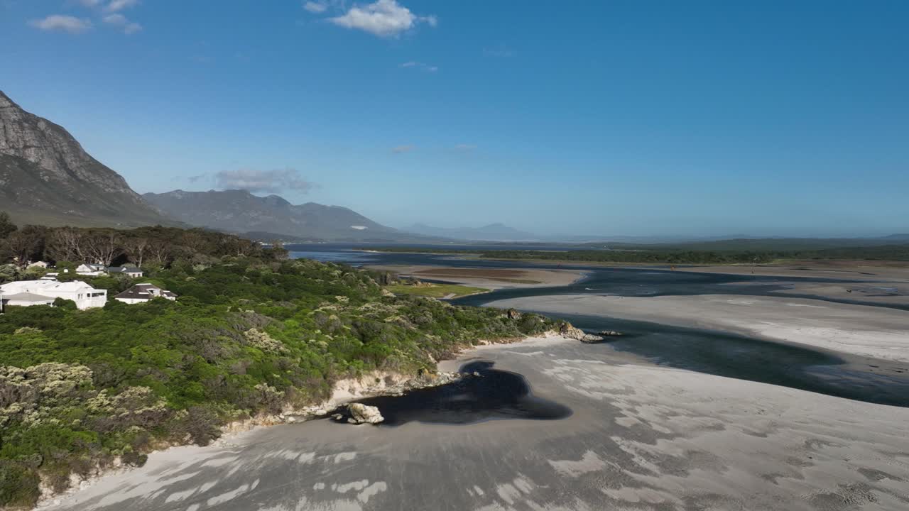toma aérea de drones de casas costeras en la playa de hermanus en un día soleado