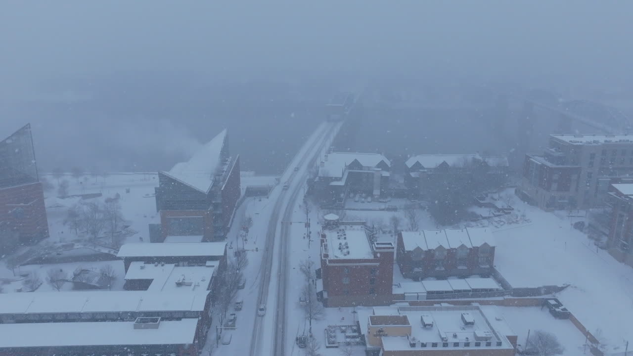 Aerial footage flying over Market Street towards the Tennessee River during a snowstorm in Chattanooga, TN.