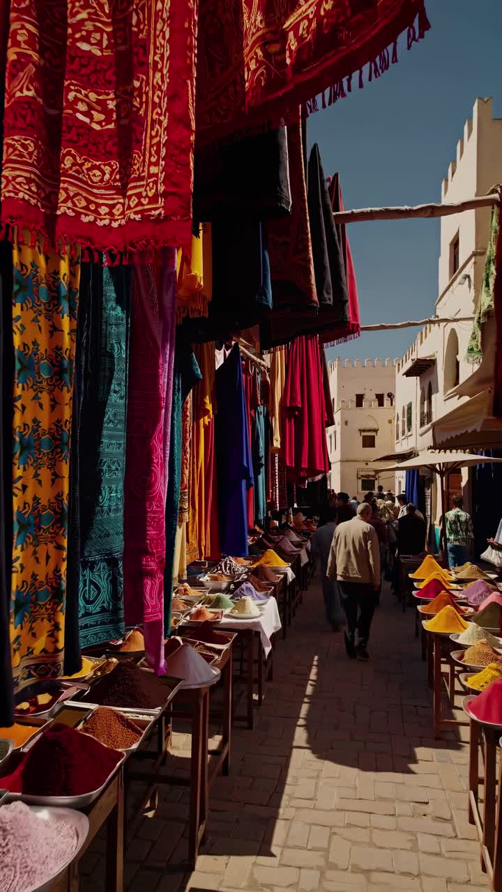 Vibrant market scene captured in a street-level video angle, showcasing colorful textiles and spices