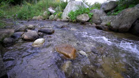 Kleiner-Bach-Mit-Schnell-Fließendem,-Frischem,-Sauberem-Wasser-Zwischen-Steinen,-Statische-Nahaufnahme