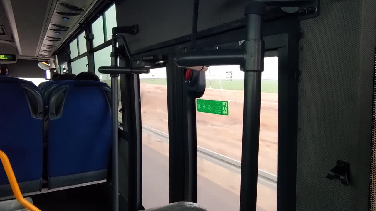 The bus is empty. The seats are blue. Transportation in road.