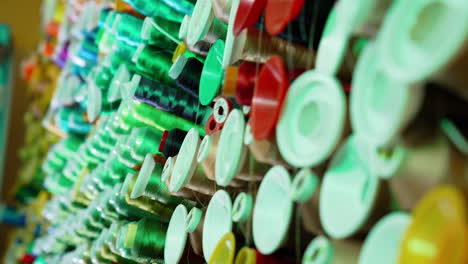 Rolls of threads hanging on a wall. Colorful sewing tools on a wall.
