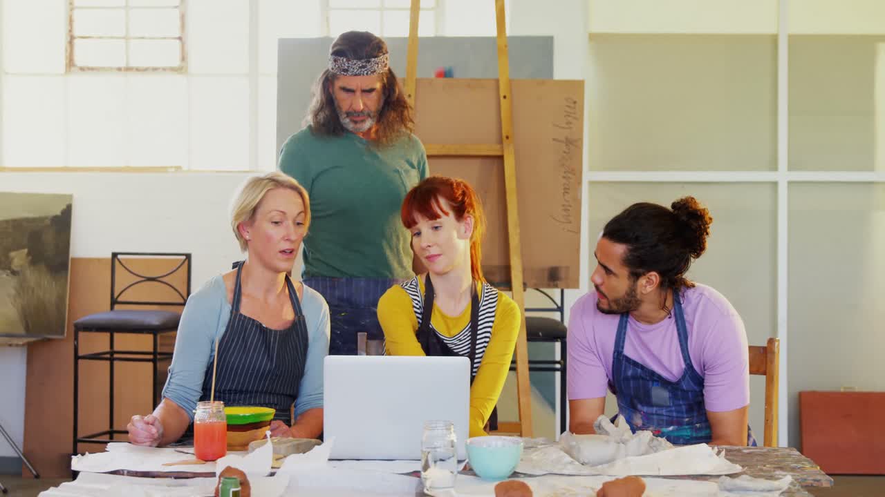 grupo de artistas usando computadora portátil en la mesa 4k