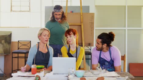 group of artists using laptop at table 4k