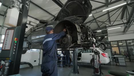 mechanic repairing car engine in auto workshop