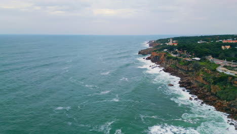 aerial cloudy coastal scenery with foamy ocean waves breaking of coast cliffs.