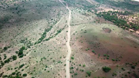 African-Landscape-With-Motorcycles-Traveling-Towards-Lake-Magadi-In-Kenya---aerial-top-down