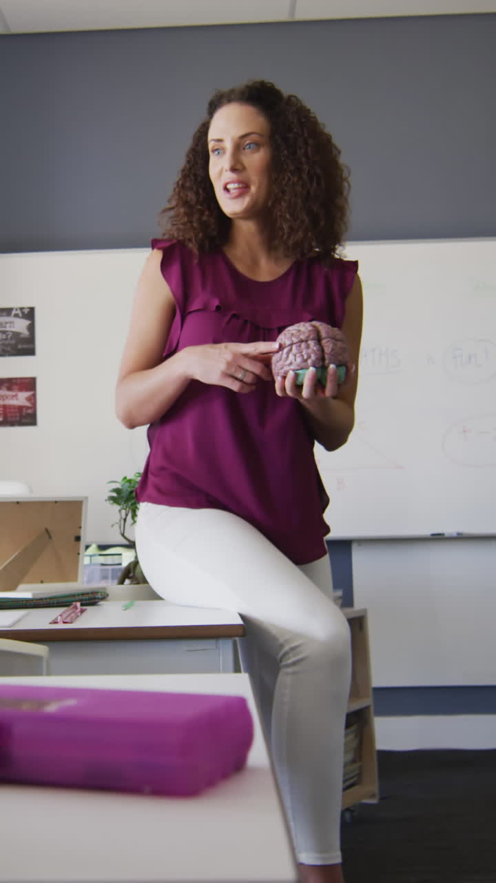 video de una maestra caucásica y niños de escuelas diversas estudiando biología en el aula