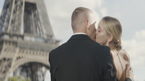 couple kissing in front of the eiffel tower