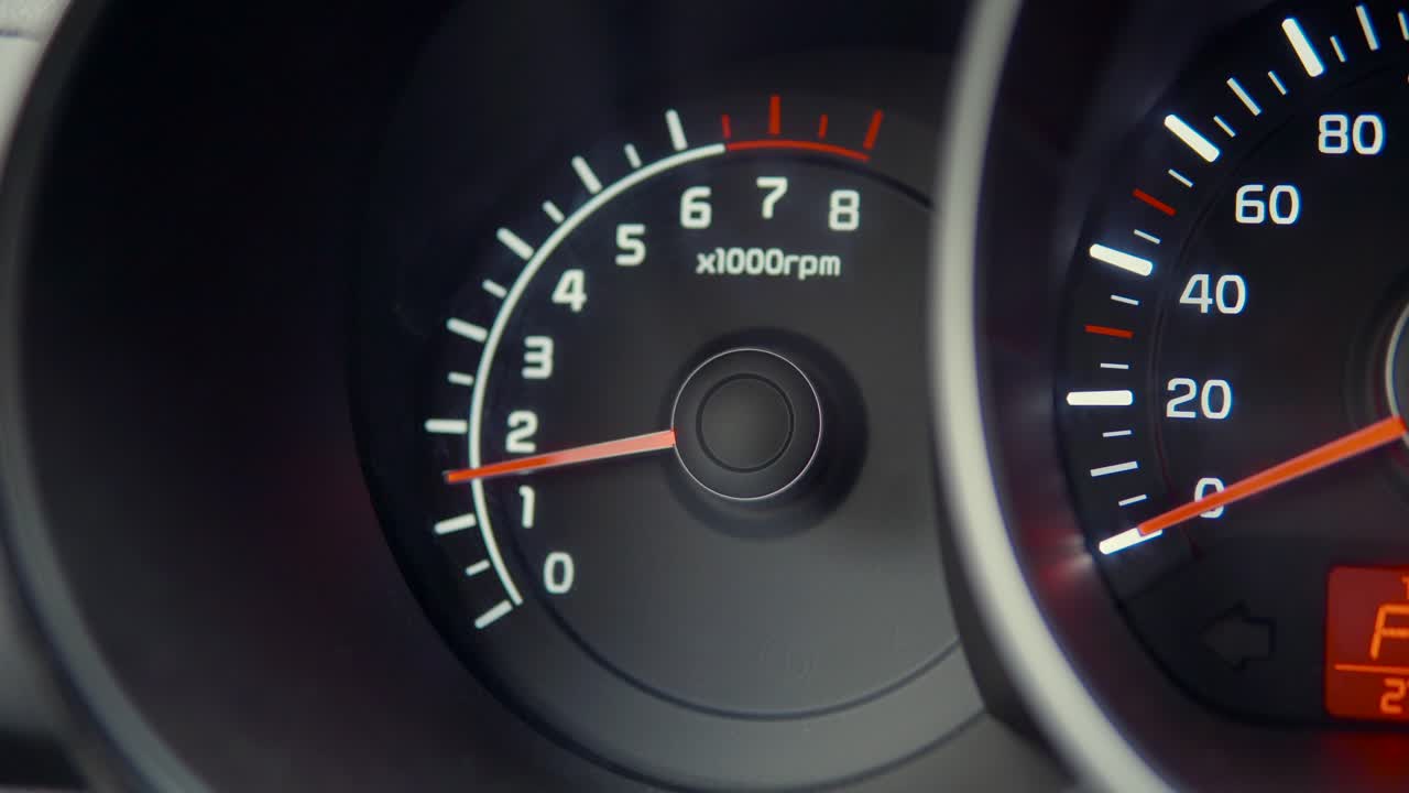 primer plano de un tacómetro y un velocímetro en el tablero de instrumentos de un automóvil