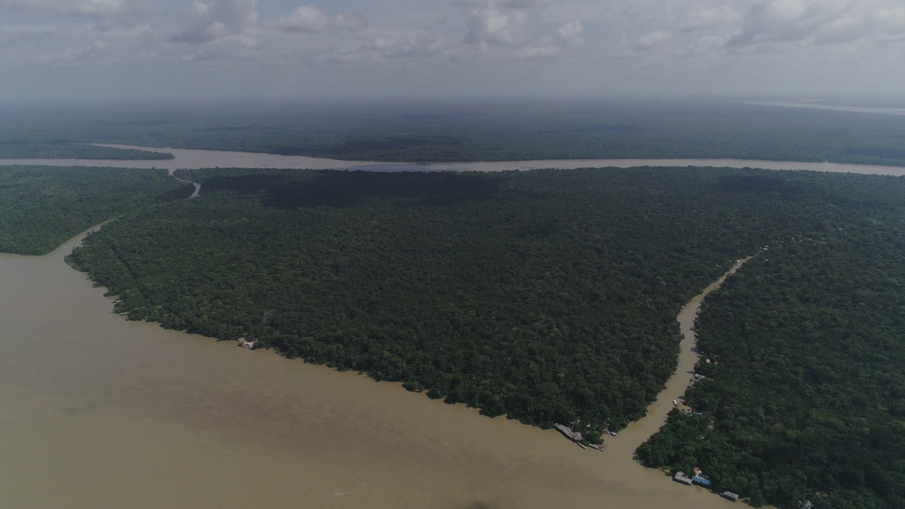 enorme río amazónico con afluentes dentro de la selva, toma aérea muy alta que muestra el horizonte